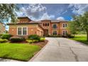 Two-story house with terracotta tile roof, landscaped yard, and a three-car garage at 20103 Shady Hill Ln, Tampa, FL 33647