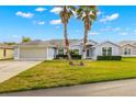 Front view of a single-story house with light blue exterior and landscaping at 29134 Caddyshack Ln, San Antonio, FL 33576