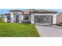 Charming single-story home featuring a well-manicured lawn and a gray two-car garage at 5479 Brussels Ter, Port Charlotte, FL 33981