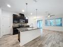 Modern kitchen with dark cabinetry, granite countertops, and stainless steel appliances at 9224 Fox Sparrow Rd, Tampa, FL 33626