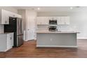 Modern kitchen with island, stainless steel appliances, and white cabinets at 7767 Peace Lily Ave, Wesley Chapel, FL 33545