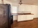White cabinets, black appliances, and laminate floors at 10642 Shalimar St, New Port Richey, FL 34654