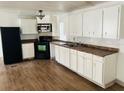 Bright kitchen with white cabinets and laminate flooring at 10642 Shalimar St, New Port Richey, FL 34654