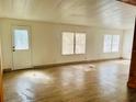 Spacious living area with wood-look floors and large windows at 10642 Shalimar St, New Port Richey, FL 34654