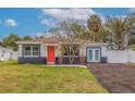 Ranch-style home with vibrant coral door at 1702 Bayou Grande Ne Blvd, St Petersburg, FL 33703