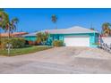 Bright teal single-story home with a white garage door and neatly trimmed hedges at 2010 E Vina Del Mar Blvd, St Pete Beach, FL 33706