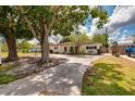 Well-maintained single-story home featuring a concrete driveway and mature trees at 8950 3Rd N St, St Petersburg, FL 33702