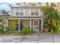 Two-story home with screened porch, lush landscaping, and driveway at 7103 Rangi Dr, Sarasota, FL 34230