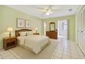 Bright bedroom with white tile floors, a ceiling fan, and a sliding glass door to the porch at 11200 102Nd Ave # 136, Seminole, FL 33778