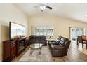 Relaxing living room featuring leather furniture, wood floors and large windows at 2700 Hawk Roost Ct, Holiday, FL 34691