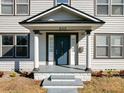 Front entrance with blue door, white columns, and stone steps at 500 53Rd S St, St Petersburg, FL 33707