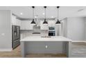 Modern kitchen with a large island, white cabinets and stainless steel appliances at 6141 Dusk Rose Ln, Brooksville, FL 34601