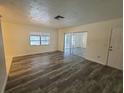 Bright living room with wood-look floors and sliding glass doors at 7125 Cambridge St, Spring Hill, FL 34606