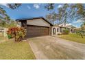 Home with a dark brown garage door and stone accents at 140 Meadowlark Dr, Safety Harbor, FL 34695