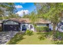 Ranch style home with a two-car garage and mature landscaping at 140 Meadowlark Dr, Safety Harbor, FL 34695