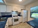 Bright kitchen with white cabinets and blue countertops at 1504 Mission Hills Blvd # 19C, Clearwater, FL 33759