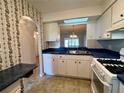 Bright kitchen features white cabinets, and a view into the dining area at 1504 Mission Hills Blvd # 19C, Clearwater, FL 33759