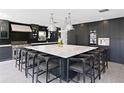 Modern kitchen with large island, marble countertops, and dark cabinetry at 2599 W Bay Isle Se Dr, St Petersburg, FL 33705
