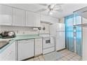 A compact and efficient kitchen featuring white appliances, cabinetry, and a light blue countertop at 3361 Scorecard Dr # 0, New Port Richey, FL 34655