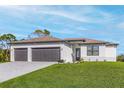 Beautiful single-story home featuring a manicured lawn, three-car garage and neutral color palette at 4570 Gillot Blvd, Port Charlotte, FL 33981