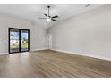 Spacious living room with wood-look floors, a ceiling fan, and sliding glass doors to the backyard at 4570 Gillot Blvd, Port Charlotte, FL 33981