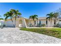 Single story house with a two car garage and palm trees at 17161 2Nd St E, North Redington Beach, FL 33708