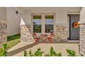 Front porch with stone details, a bistro set and wreath at 30684 Penny Surf Loop, Wesley Chapel, FL 33545