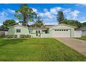 Light green house with a two-car garage and a large front yard at 3887 50Th S Ave, St Petersburg, FL 33711