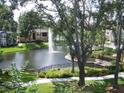 View of the community pond with fountain, lush landscaping, and walkways at 10108 Courtney Oaks Cir # 203, Tampa, FL 33619