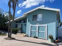 Charming blue home featuring a unique facade, lush greenery, and well-maintained landscaping at 514 161St Ave, Redington Beach, FL 33708