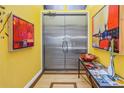 Stylish entryway with yellow walls, metallic double doors, and artwork at 838 Monterey Ne Blvd, St Petersburg, FL 33704