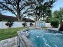 Backyard features a modern hot tub, green lawn, privacy fence and shed at 2353 Kilgore Dr, Largo, FL 33770