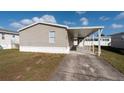Front view of a tan mobile home with carport at 38029 Leondias Dr, Zephyrhills, FL 33542