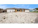 House exterior features a white brick facade, stone accents, and a large gravel driveway at 1117 Rushmore Dr, Holiday, FL 34690