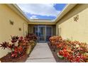 Front entry with a screened porch and colorful landscaping at 5220 Butterfly Shell Dr, Apollo Beach, FL 33572