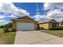 Tan house with white garage door and a paved driveway at 5220 Butterfly Shell Dr, Apollo Beach, FL 33572