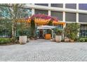 Building entrance with lush landscaping and seating at 1000 Water St # 1702, Tampa, FL 33602