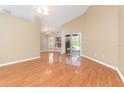 Bright and airy living room features gleaming hardwood floors, high ceilings, and sliding glass doors at 27542 Sky Lake Circle, Wesley Chapel, FL 33544