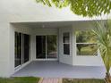 Covered patio with light grey paint job, sliding glass doors, and view of the backyard at 27542 Sky Lake Circle, Wesley Chapel, FL 33544