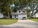 Beautiful two-story house with white siding, a front porch, and a long driveway with parked car at 5303 W Cleveland St, Tampa, FL 33609