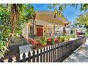 Lovely home featuring a cozy front porch, decorative iron railings, colorful flowers, and a dark picket fence at 2905 N 13Th St, Tampa, FL 33605