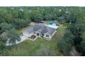 Aerial view of house, pool, and surrounding land at 8108 Indian Trail Rd, Weeki Wachee, FL 34613