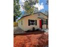 Side view of the house with red door and well-maintained landscaping at 8111 N 12Th St, Tampa, FL 33604