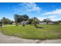 Expansive front yard with mature landscaping and a well-maintained lawn showcases curb appeal at 15272 Spinning Wheel Ln, Brooksville, FL 34604