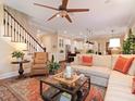 Inviting living area featuring hardwood floors, a ceiling fan, stairs, and a comfortable sofa and chair at 3106 W Bay Villa Ave, Tampa, FL 33611
