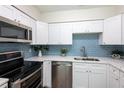 Modern kitchen features stainless steel appliances, white cabinets and a stylish backsplash at 514 Crestover Dr, Temple Terrace, FL 33617