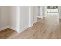 Hallway featuring beautiful wood-style flooring and neutral paint, leading to the main living area at 13110 Homestead Ln, Parrish, FL 34219