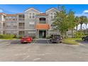 Two-story building with gray siding, orange roof, and ample parking at 18001 Richmond Place Dr # 734, Tampa, FL 33647