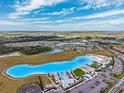Aerial view of community with resort-style pool and surrounding homes at 16701 Maude Dr, Wimauma, FL 33598
