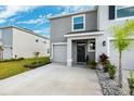 Townhome with gray exterior, two-car garage, and front landscaping at 16701 Maude Dr, Wimauma, FL 33598